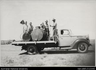 scanned image of four workers on the back of a lorry circa early 1900s